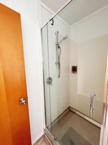 a shower in a bathroom with a glass door at Kingswood Manor Motel in Whangarei