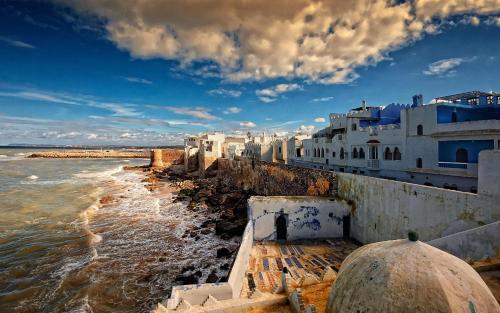 a group of buildings on the shore of the water at Chez Charifa in Asilah