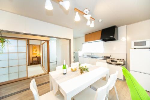 a kitchen with a white table and white chairs at Yokkaichi Kawaramachi Hotel in Hazu