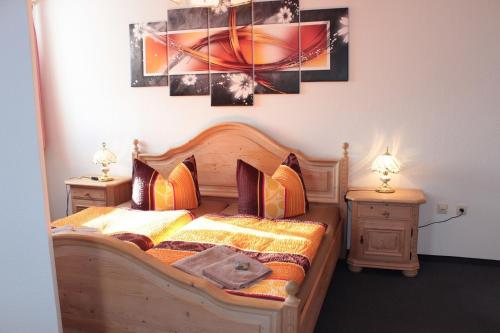 a bedroom with a wooden bed with two night stands at Hotel Stadt Pausa in Pausa
