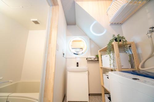 a small bathroom with a toilet and a sink at Yokkaichi Kawaramachi Hotel in Hazu