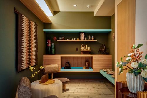 a living room with green walls and a table and chairs at LiveGRACE Hotel Azabu 麻布芝公園 in Tokyo