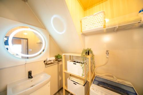 uma casa de banho com um lavatório e um espelho em Yokkaichi Kawaramachi Hotel em Hazu