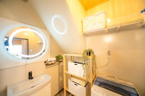 a bathroom with a sink and a mirror at Yokkaichi Kawaramachi Hotel in Hazu
