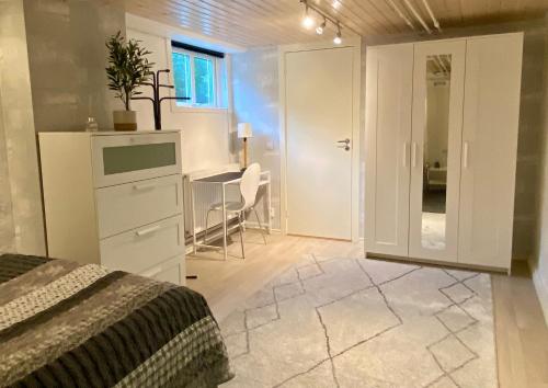 a bedroom with a bed and a desk and a table at Lower floor of 50 sqm in nice villa with parking in Stockholm