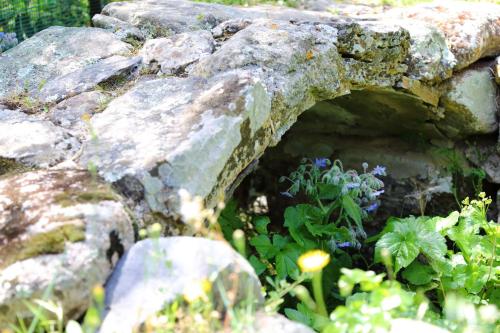 a pile of rocks in a garden with flowers at B&B Nuraximannu in Santadi