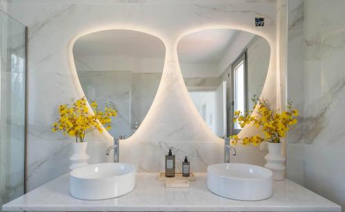 - une salle de bains blanche avec deux lavabos et un miroir dans l'établissement Villa Sadova Private pool Panoramic view, à Kalamata