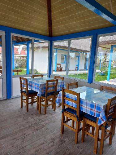 a dining room with tables and chairs and windows at Stuffino Crisan in Crisan