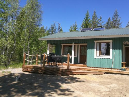 une serre avec une terrasse et une table dans l'établissement ILO103, à Huhus