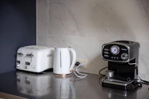 a counter top with a toaster and a coffee maker at Finsbury House - Luxury 8 Bedroom Farm Homestead with Pool in Kilmore