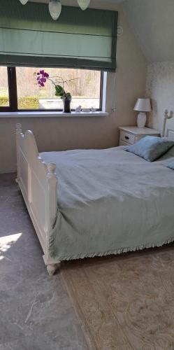 a white bed in a bedroom with a window at room to the east in Viimsi