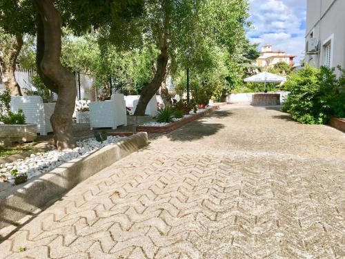 a cobblestone walkway with trees and a building at Villa Paestum in Paestum