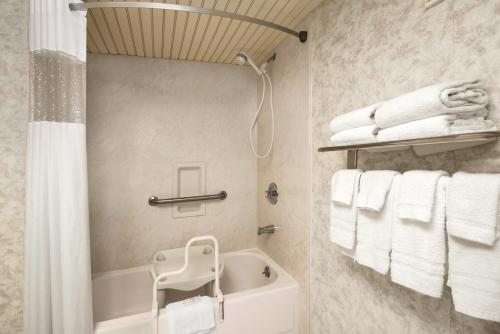 a bathroom with a tub and white towels at Space Coast Hotel Titusville-Kennedy Space Center in Titusville