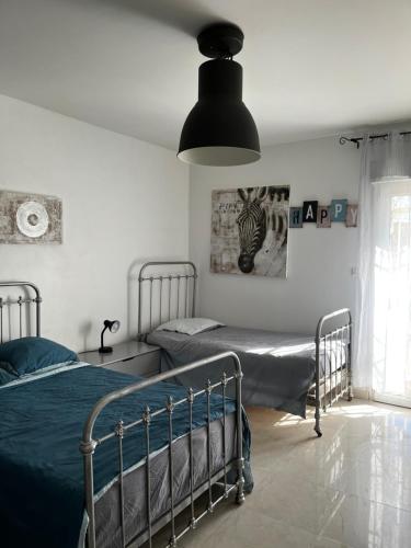 um quarto com 2 camas e um candeeiro preto em LAubergerie de Lastours em Coursan