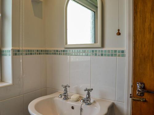 baño con lavabo y ventana en Rivendell en Burgh by Sands
