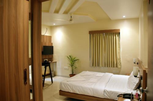 a bedroom with a bed and a desk in it at The Byke Skylark Seafront Resort, Dapoli in Murūd