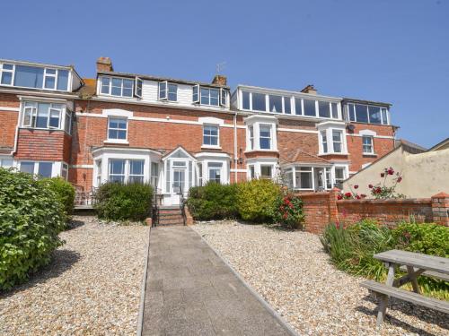 a large brick building with a bench in front of it at 3 Cobb View in Lyme Regis