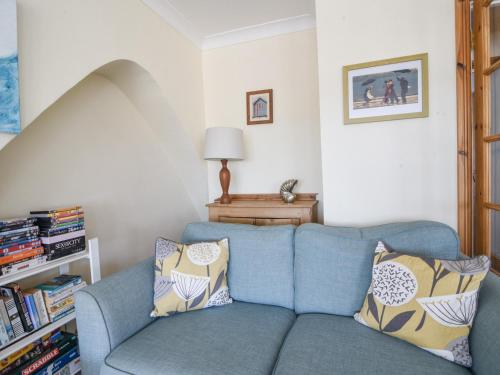 a blue couch with pillows in a living room at 3 Cobb View in Lyme Regis
