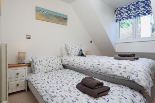 een slaapkamer met 2 bedden en handdoeken bij Seaspray in Dartmouth