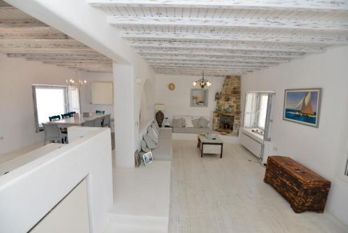 a living room with white walls and a wooden ceiling at Mykonos 4 bedroom Cycladic home with free parking in Ano Mera