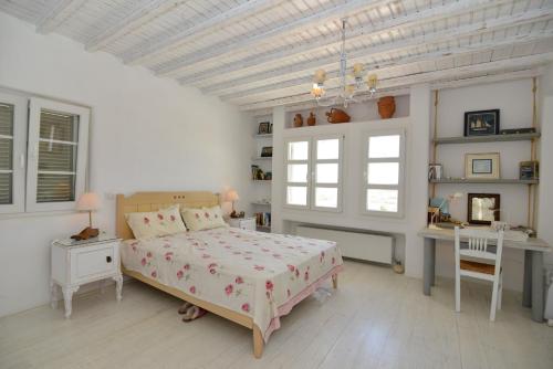 a bedroom with a bed and a desk and window at Mykonos 4 bedroom Cycladic home with free parking in Ano Mera