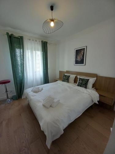 - un grand lit blanc dans une chambre lumineuse dans l'établissement Cozy Home Center of Antibes, à Antibes