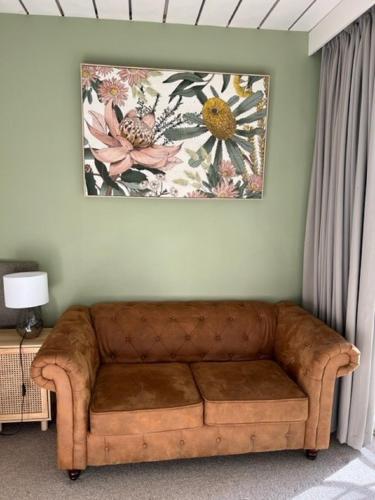 a couch in a living room with a painting on the wall at Riverbank Park MOTEL in Bright