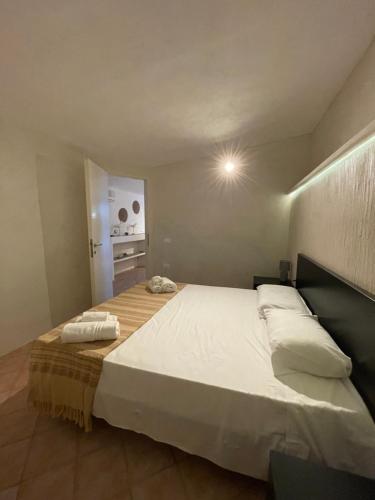 een slaapkamer met een groot bed met witte lakens bij B H Lampedusa in Lampedusa