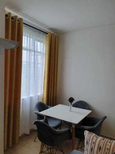 a table and chairs in a room with a window at Airview Apartments in Nairobi
