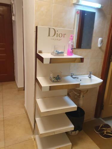 a bathroom with a sink and a mirror and a sink at Airview Apartments in Nairobi