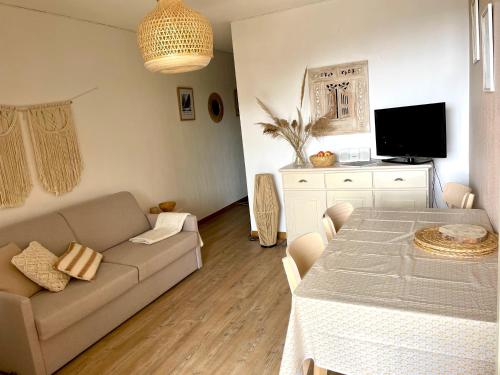 a living room with a couch and a table at Le pothuau studio 2 pièces proche plage vue mer in Hyères