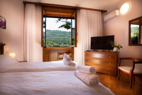 una camera con due letti, una TV e una finestra di SunLake Hotel a Riva del Garda