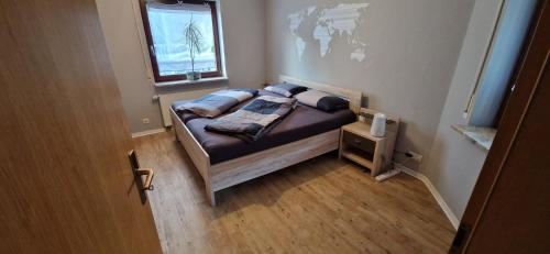 - un petit lit dans une petite chambre avec fenêtre dans l'établissement Ferienwohnung in zentraler Lage und Kurparknähe, à Bad Lauterberg