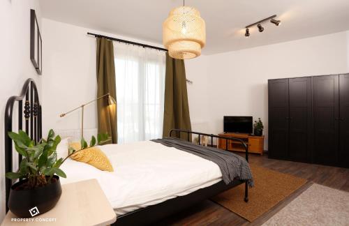 - une chambre avec un lit et une plante en pot dans l'établissement Stylish Concept Studio, à Bucarest