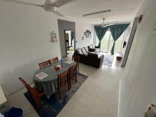 Homestay Ar Rayyan RESIDENSI LAGUNA BIRU في راوانغ: غرفة معيشة مع طاولة وكراسي وأريكة