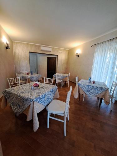 a dining room with two tables and white chairs at Tenuta Costa in Palma di Montechiaro