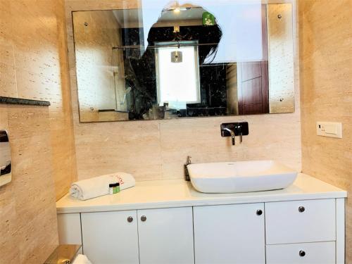 a bathroom with a sink and a mirror at Lime Tree Hotel Pulkit Gurgaon-Artemis Hospital, Nearest Metro Huda City Centre in Gurgaon
