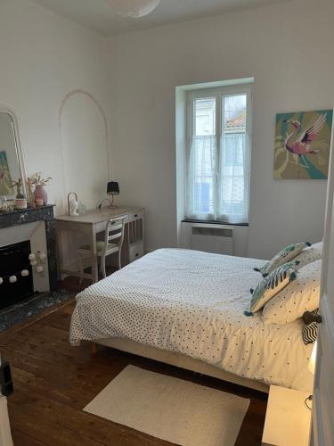 une chambre avec un lit, un bureau et une fenêtre dans l'établissement Propriété IØ8 - Oléron, à Saint-Pierre-dʼOléron