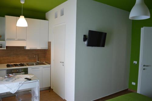a kitchen with white cabinets and a tv on the wall at Casa Magistrale in Trapani