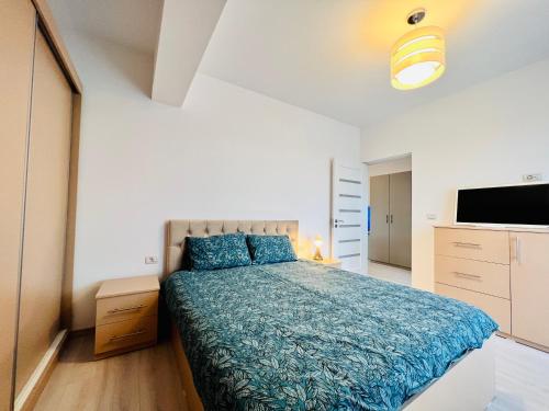 a bedroom with a bed with a blue comforter at Altheda Living Zamca C4 in Suceava