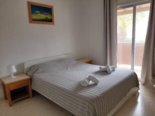 a bedroom with a bed with two towels on it at Ariadne Apartments in Paphos City