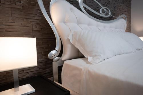 Un dormitorio con una cama blanca y una lámpara en una mesa en iitana Luxury Apartment - Catania Fronte Mare en Catania