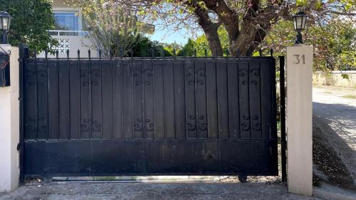 a black gate in front of a house at artemis homest ay ,two-bedroom apartment in Artemida