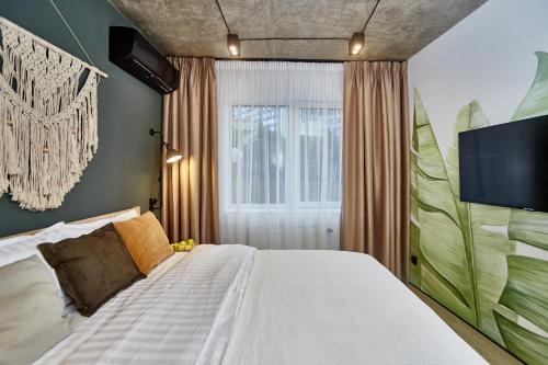 een slaapkamer met een groot bed en een televisie bij City Rooms Arcadia Self Check-In in Odessa