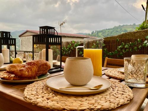una mesa con un plato de comida y un vaso de zumo de naranja en La Pedrosa, en Fontanina