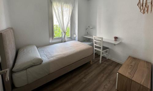 a bedroom with a bed and a desk and a window at Slow Room Valencia in Valencia