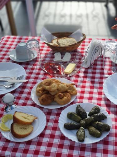 a table with plates of food on a red and white table cloth at Castle Hotel in Gjirokastër