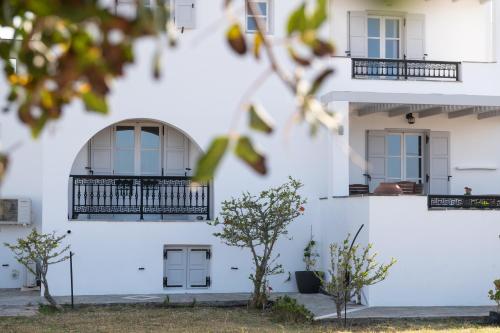 a white building with windows and a balcony at Sea Lilies Suites in Plaka