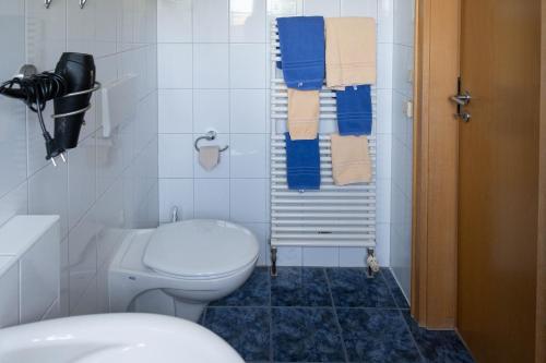 ein Bad mit einem WC, einem Waschbecken und Handtüchern in der Unterkunft Gästehaus Kölfhamm 2 in Sankt Peter-Ording
