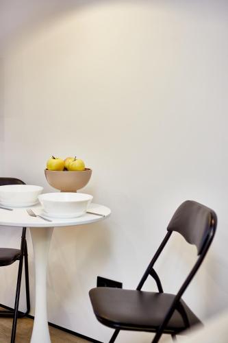 a table and chair with a bowl of fruit on it at City Rooms Arcadia Self Check-In in Odesa